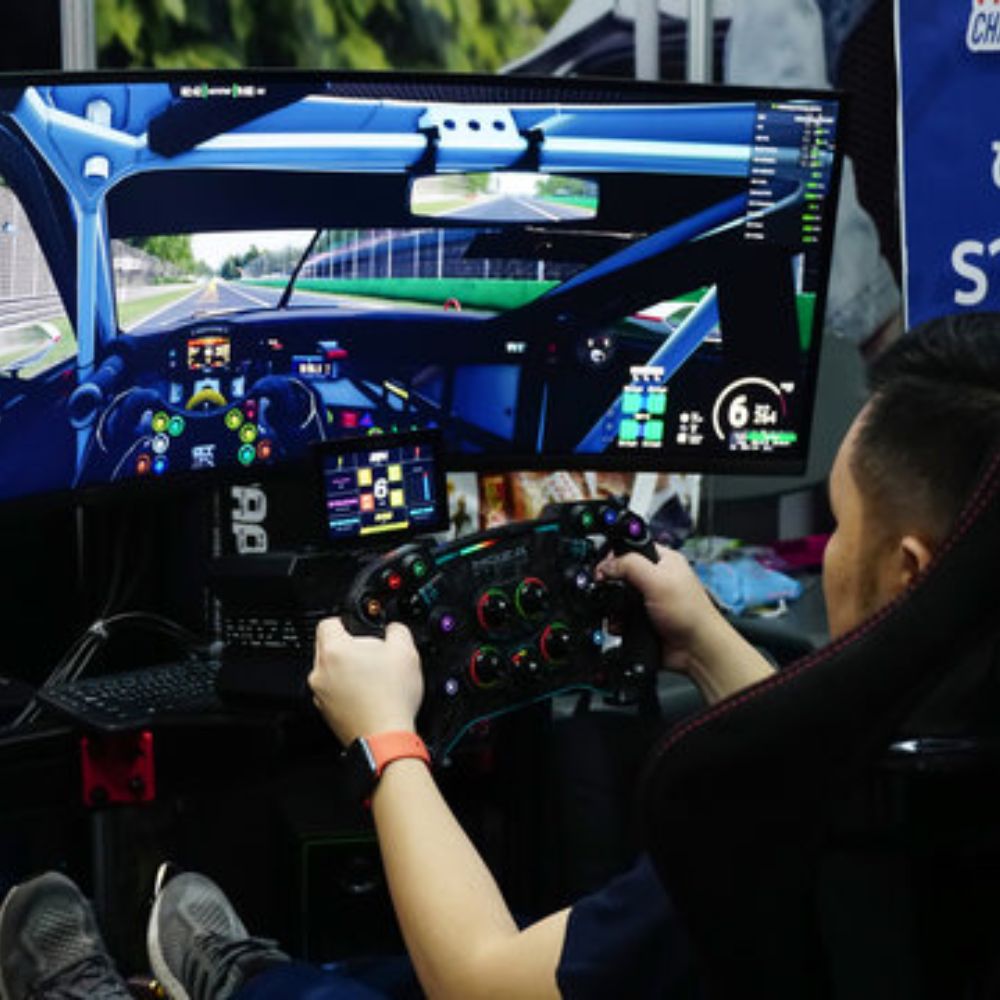 guy in a racing simulator with wide screen monitor and moza formula wheel
