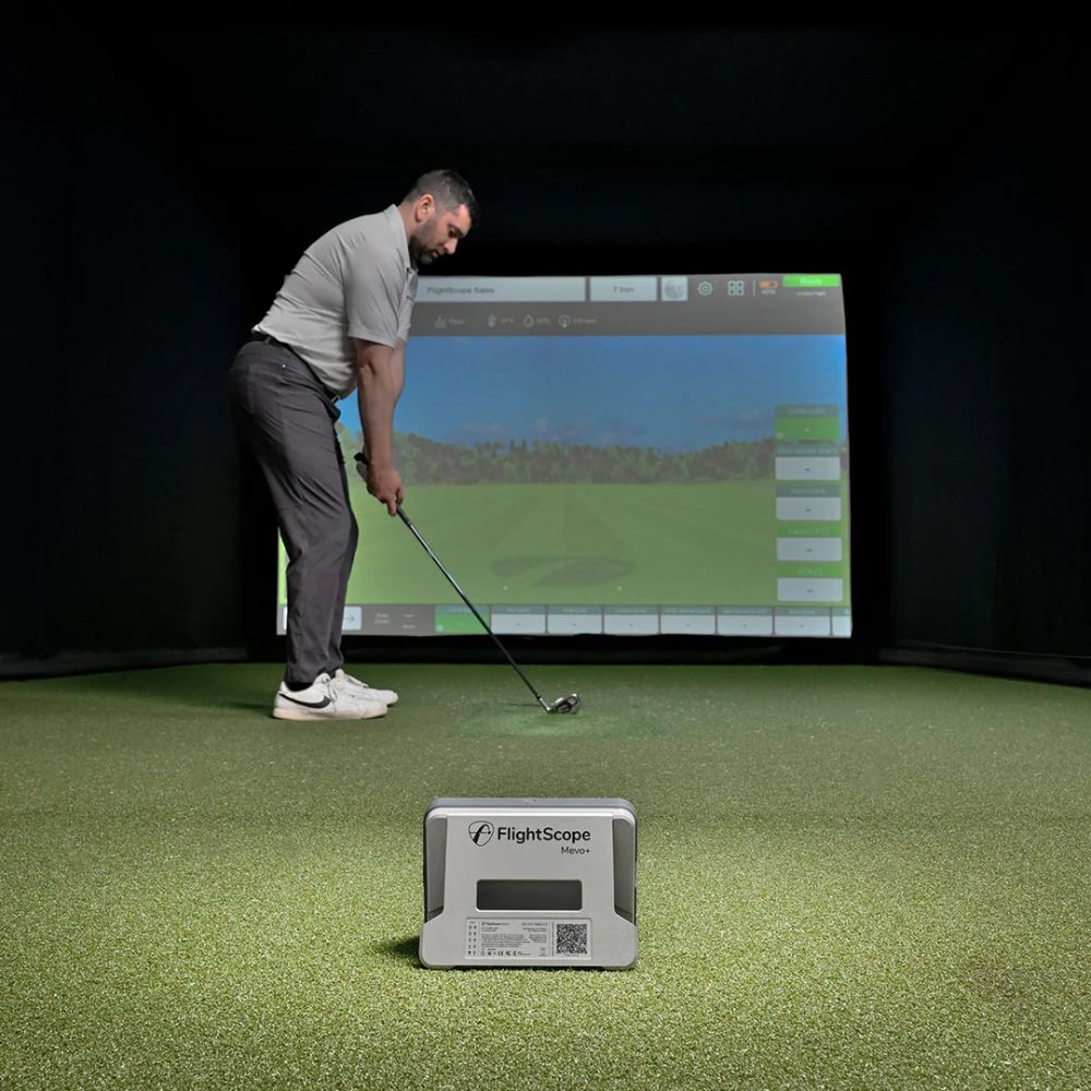 FlightScope_Mevo_golf_simulator_with_guy_playing_in_front_of_golf_sim_enclosure