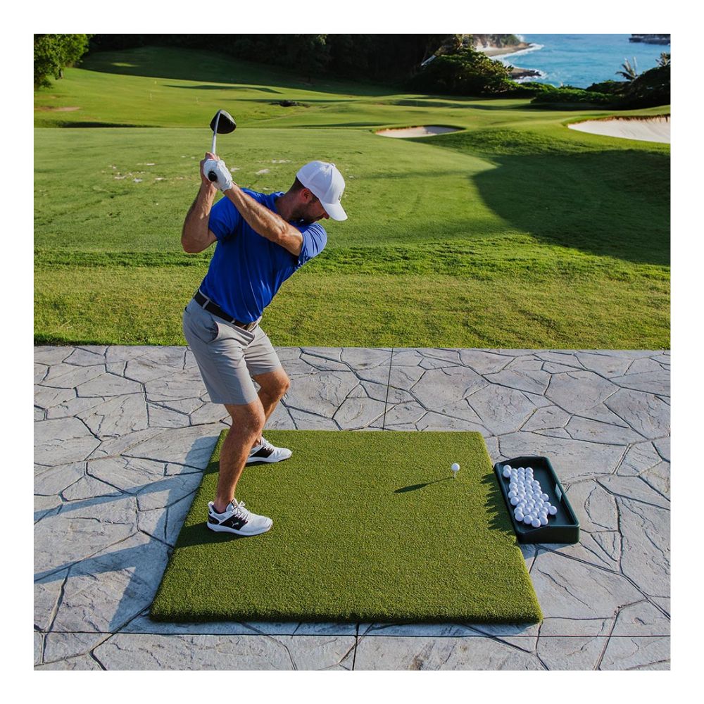 guy hitting some golf balls off a golf mat