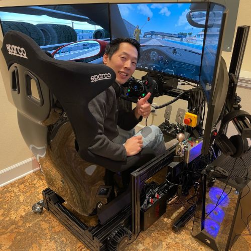 guy on a racing simulator smiling and giving the thumbs up