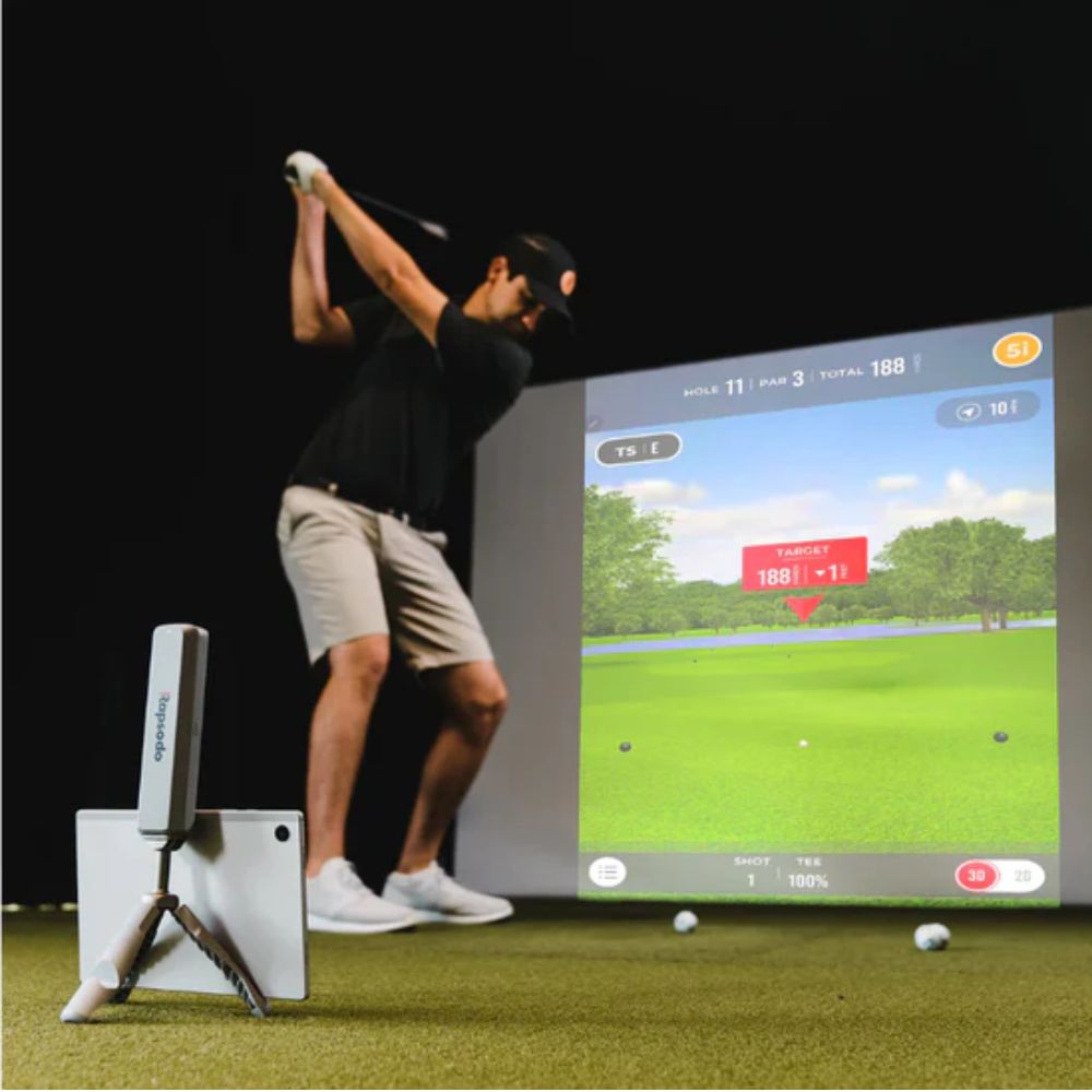 Rapsodo_MLM2PRO_golf_simulator_with_guy_playing_in_front_of_golf_sim_enclosure